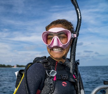 a man wearing sunglasses and standing in front of a body of water Discover scuba diving